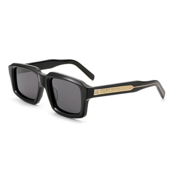 Three-quarter angle view of black Waylon Smith sunglasses on a white background, showing the Waylon Smith wordmark on the gold temple detail