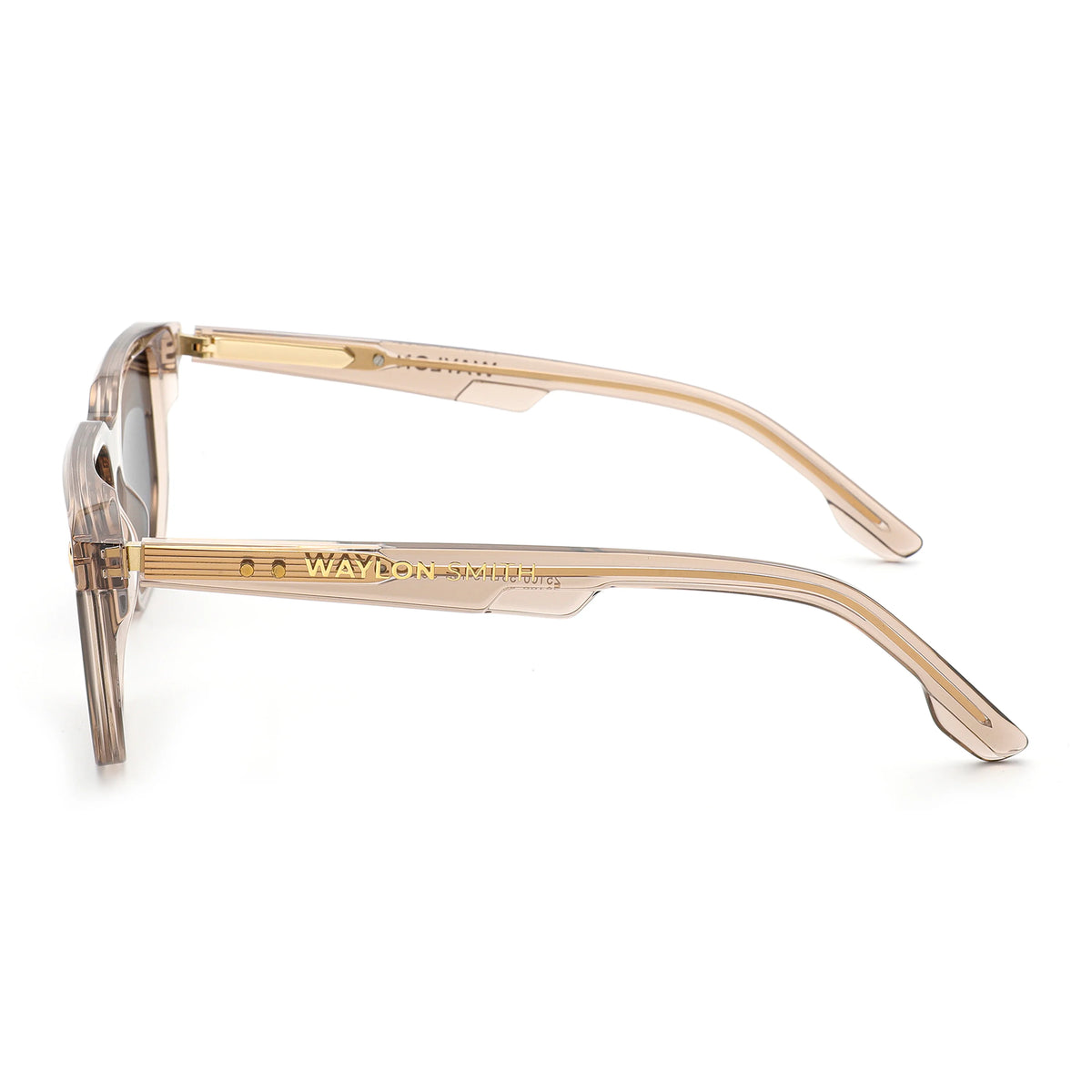 Side view of transparent champagne Waylon Smith sunglasses on a white background, showing the Waylon Smith wordmark on the temple