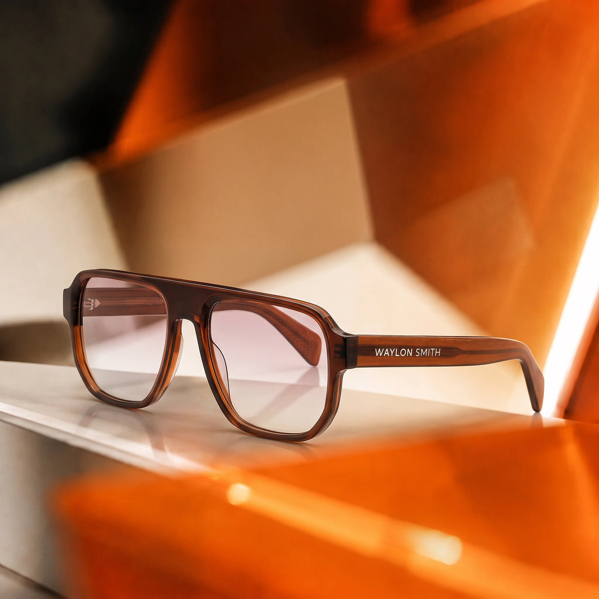 Waylon Smith sunglasses in tortoiseshell resting on a geometric surface with dramatic orange lighting, showing the Waylon Smith wordmark on the temple