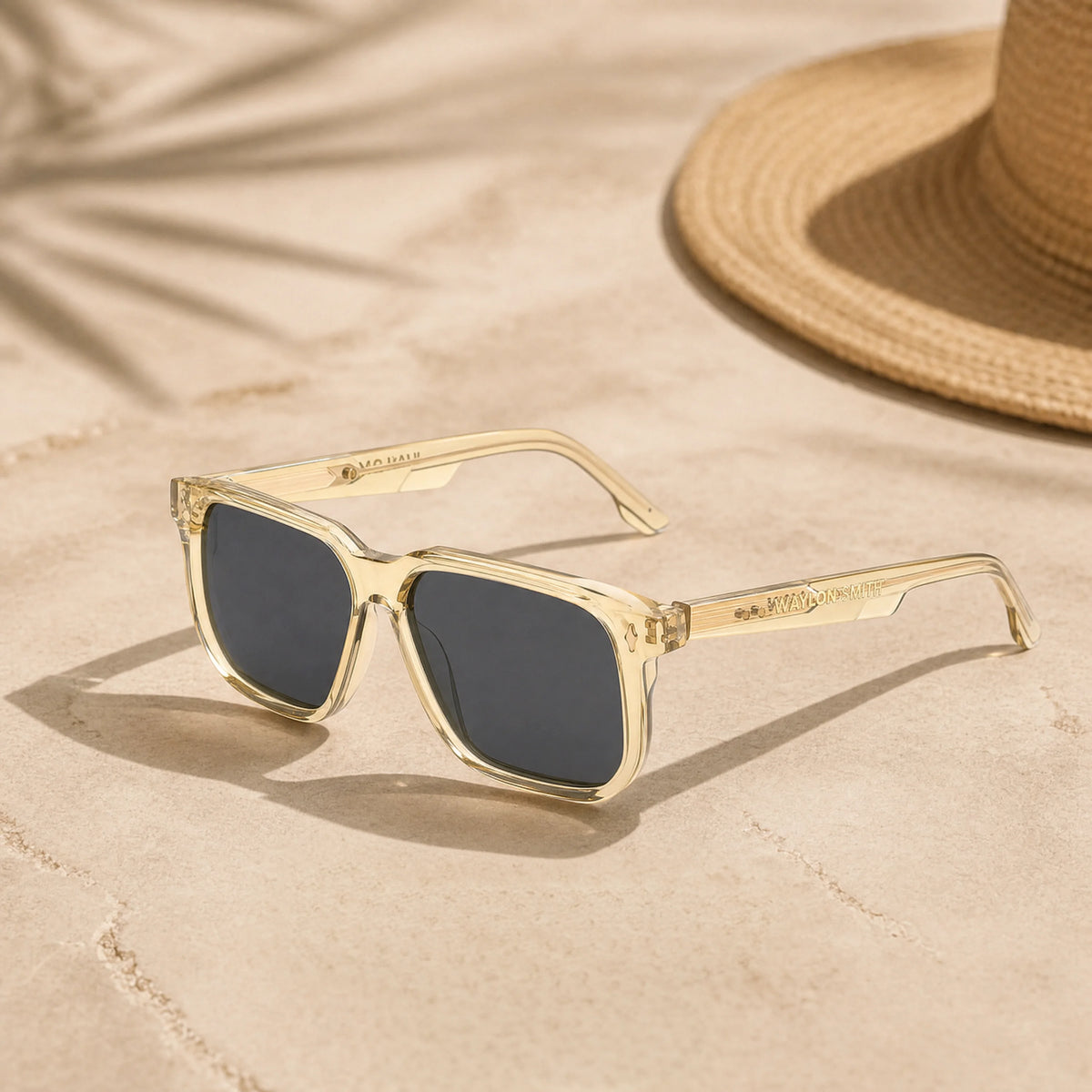 Waylon Smith The Vinewood sunglasses in Champagne Gold, lifestyle shot on sand with a straw hat