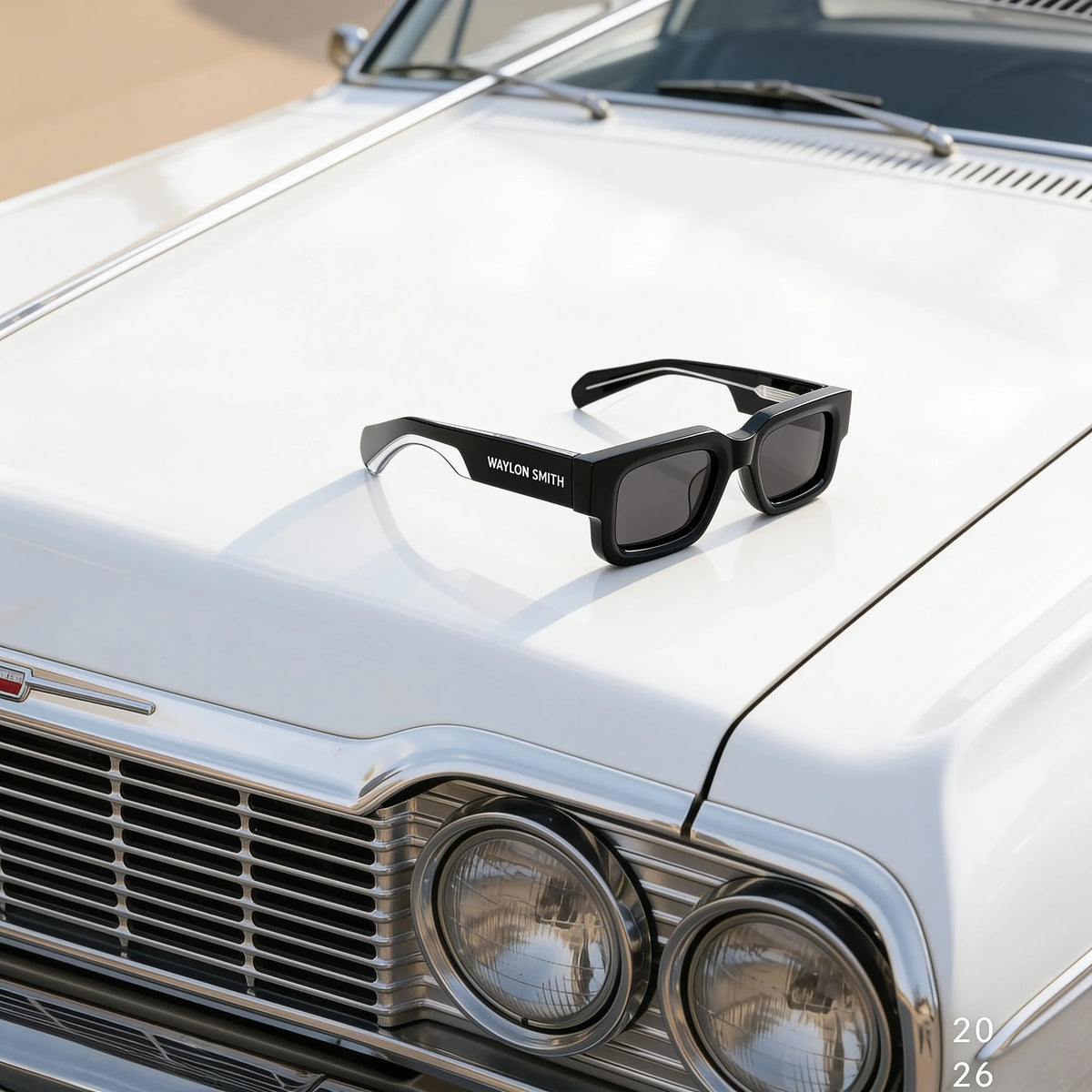 Black Waylon Smith sunglasses placed on the hood of a classic white car