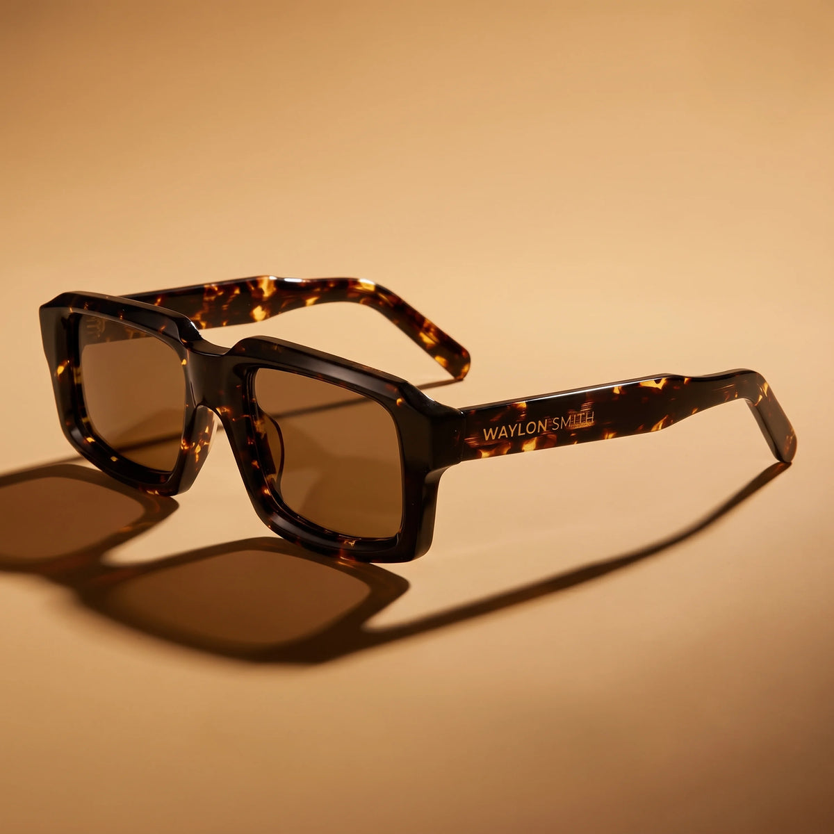 Waylon Smith sunglasses in tortoiseshell, studio product shot on a warm beige background, showing the Waylon Smith wordmark on the temple