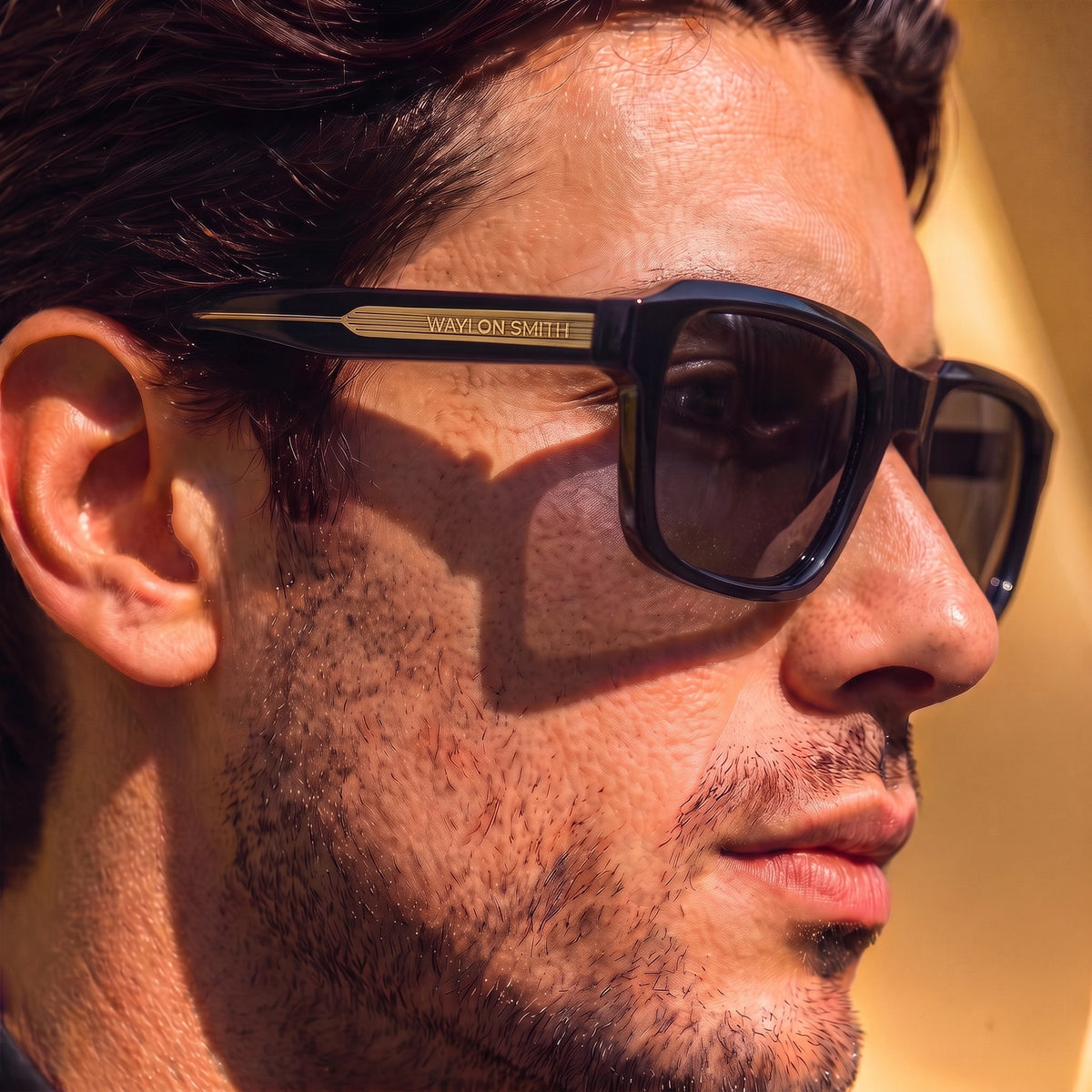 Close-up profile of a man wearing black Waylon Smith sunglasses, showing the Waylon Smith wordmark on the temple