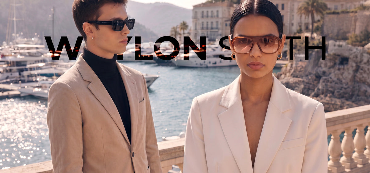 Man and woman in tailored suits wearing Waylon Smith sunglasses at a coastal marina, About page mobile bannerslider_item_TCpe3W